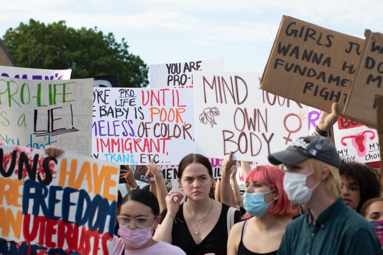 photo of people outside, protesting and holding pro abortion signs