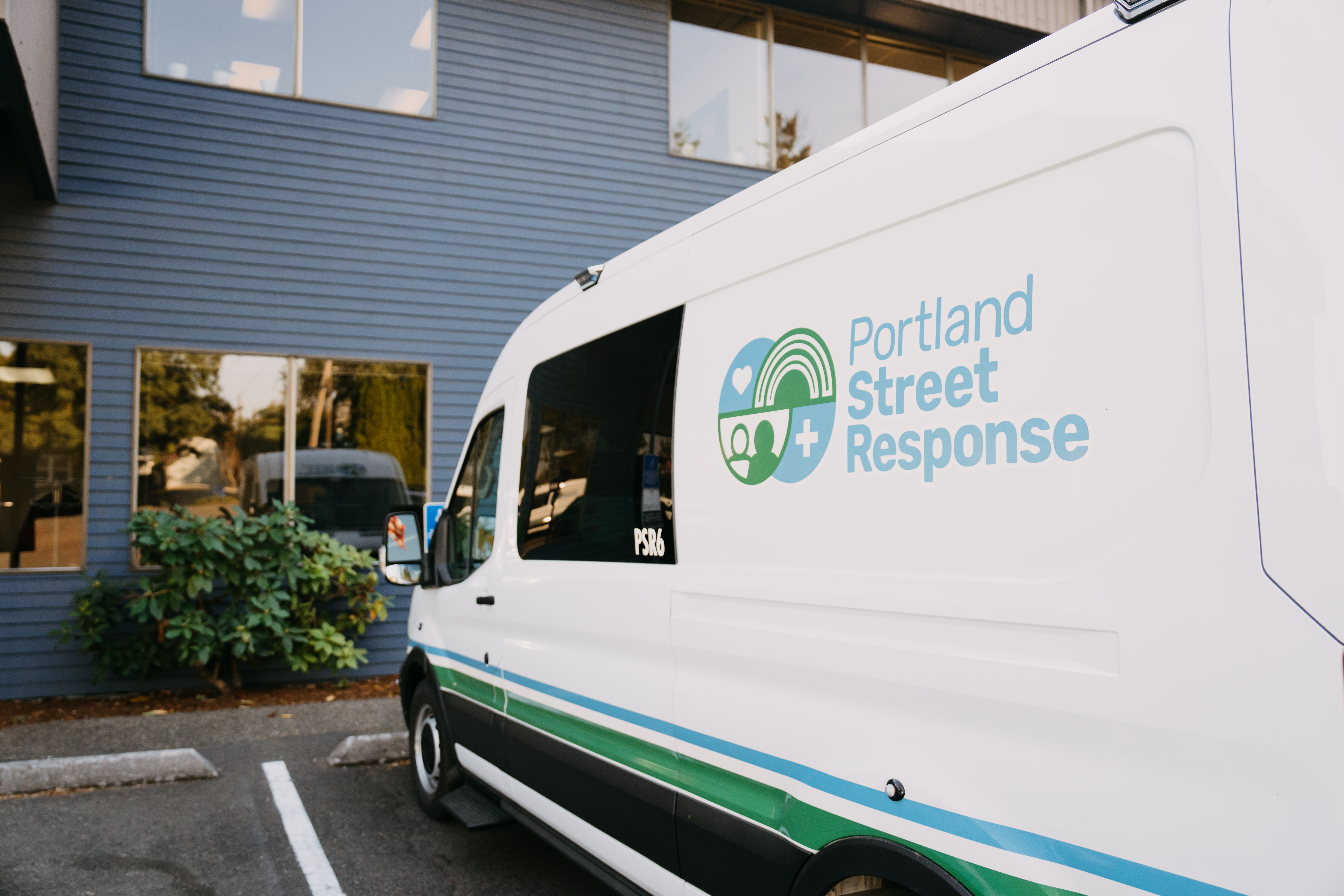 photo of a white van parked in front of a building. the van reads "portland street response"