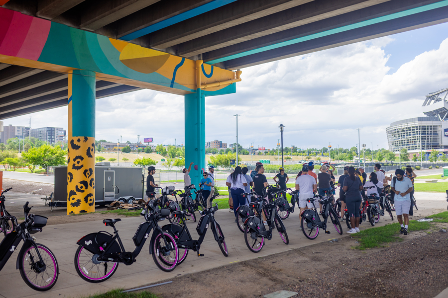 photo of a row of citybikes underneath a colorful overpass