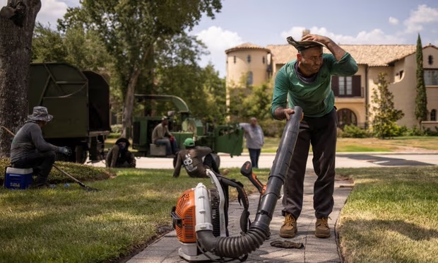 Henry Gomez uses a blower to dry his clothes after working with a crew to remove a tree during a heatwave in Houston, Texas, on 24 August. Photograph: Adrees Latif/Reuters