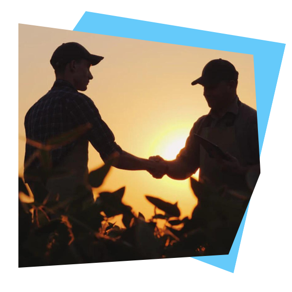 A photo of two peple wearing hats shaking hands with a setting sun behind them