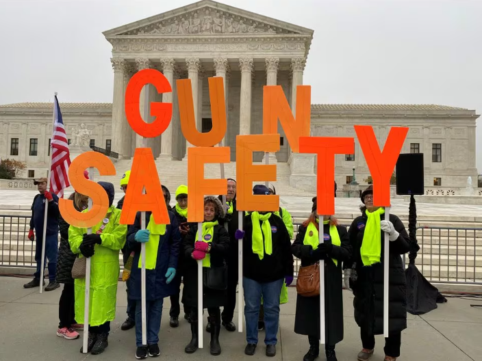 photo of people protesting outside the supreme court with letter signs that read out "Gun Safety"