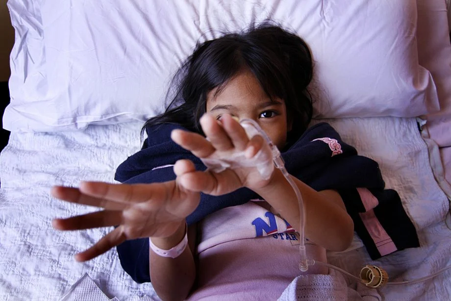 Small child receiving medical care reaching out from a bed (Photo by Dzulhaidy Abdul Rahim / CC BY-NC-ND 2.0)