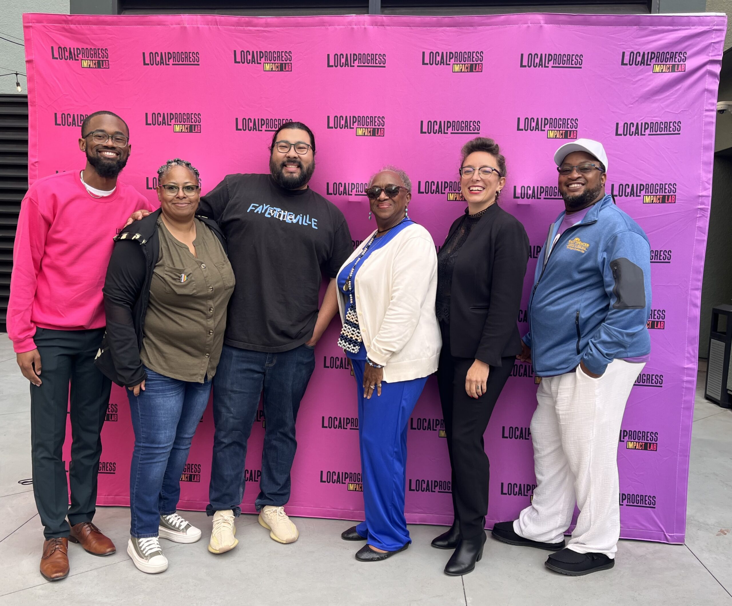 A group of LPNC members and partners posing for a photo in front of the LP step and repeat at the 2024 National Convening in Oakland, CA.