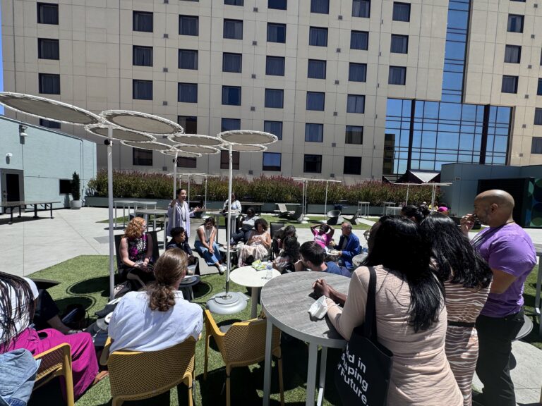 A group of people sitting around a table and talking