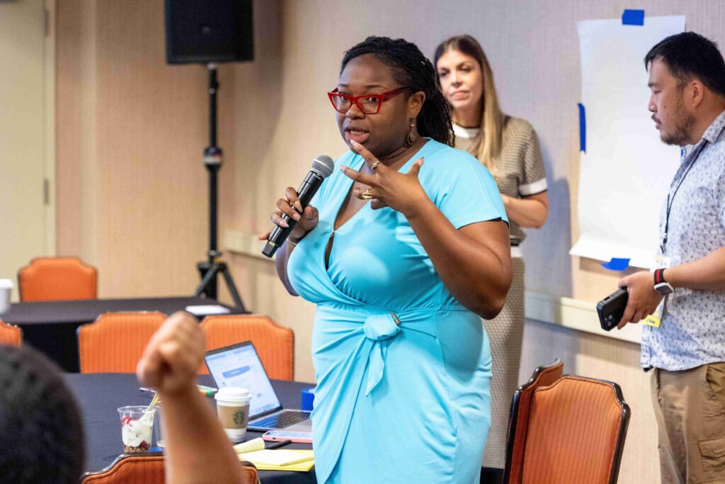 A picture of a woman holding a mic and speaking