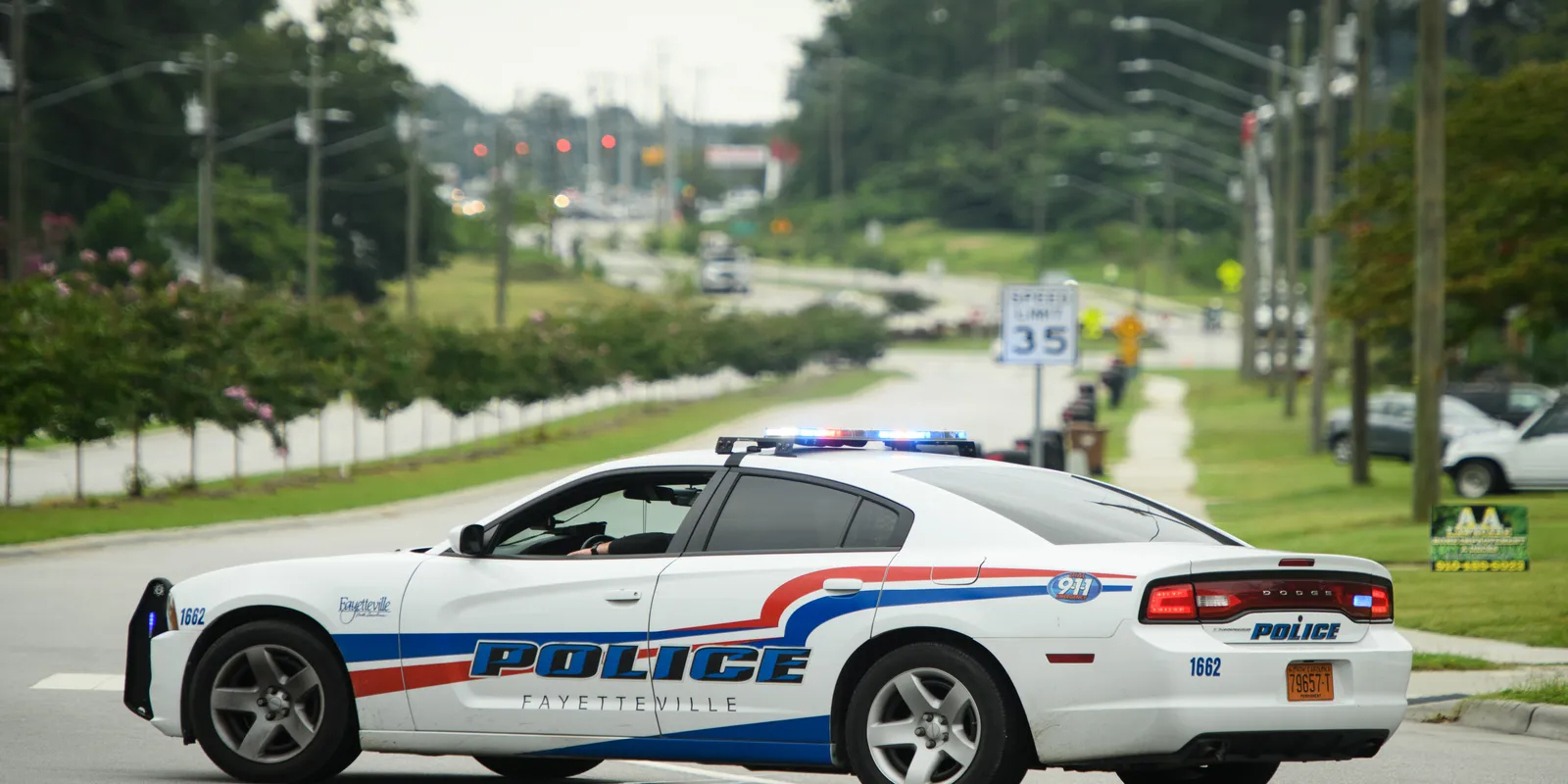 Image of a police car driving (retrieved from the Fayetteville Observer)