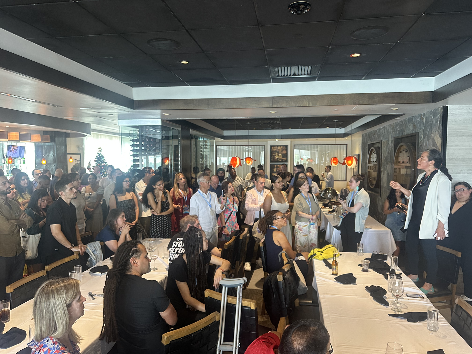 A group of people in a ballroom listening to someone speak