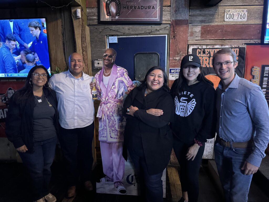 A group of people posing for a picture at a bar