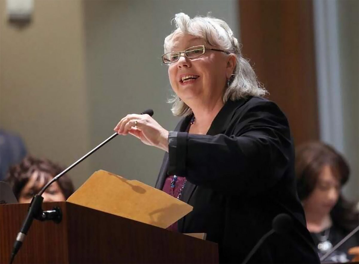 Gayle McLaughlin speaking at a podium.