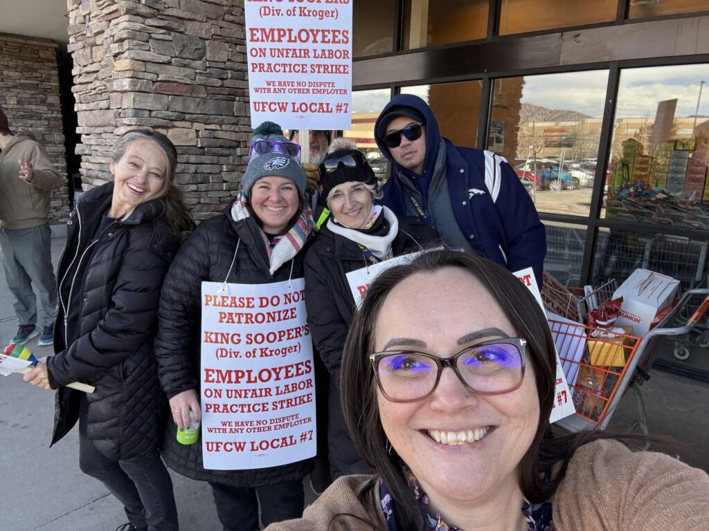 A group of people posing for pictures on a picket line