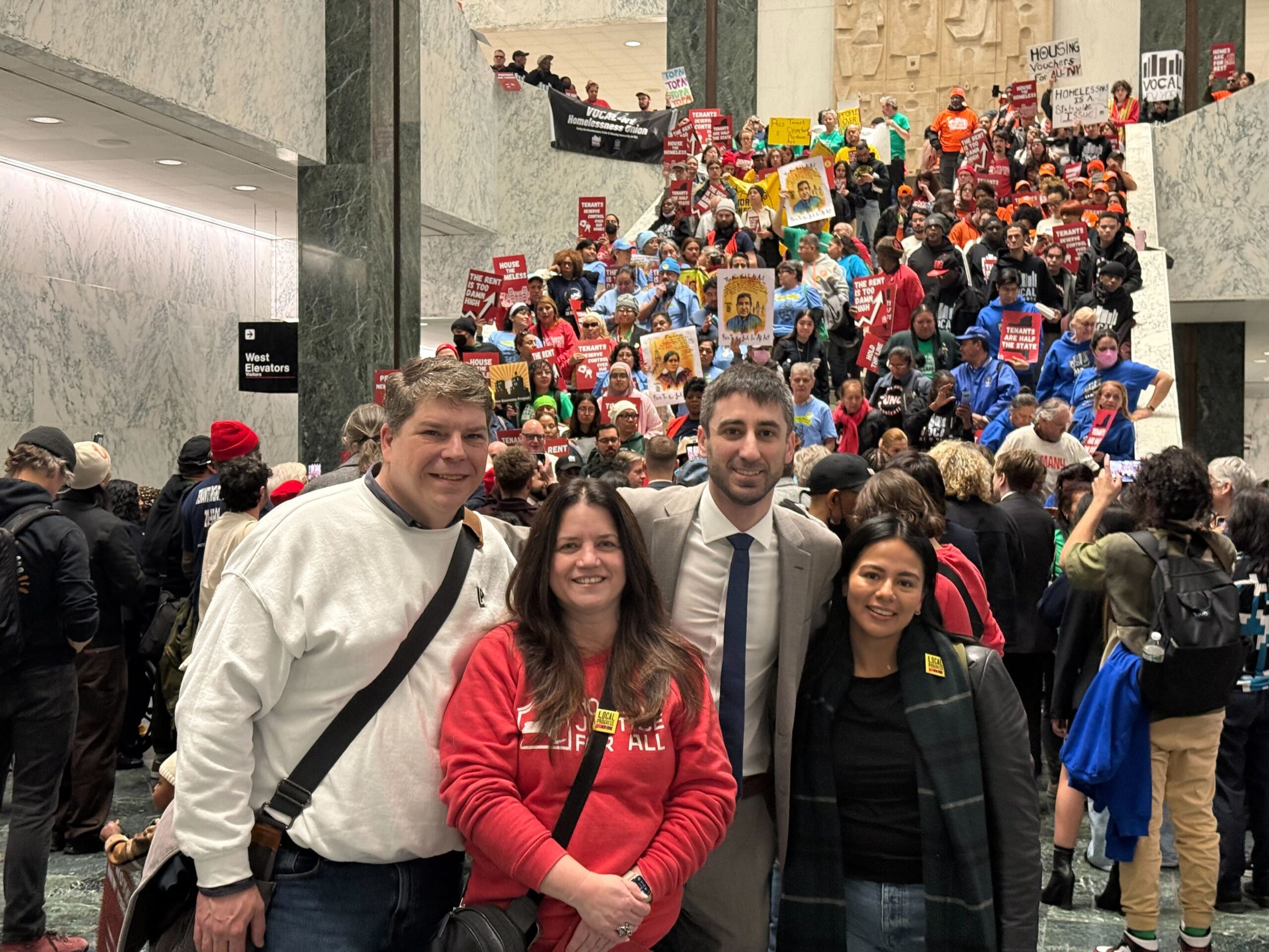A group of people posing for a picture in front of a group protesting