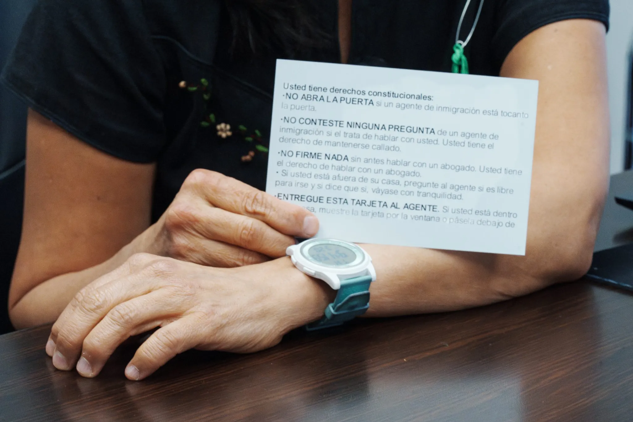 Attorney Isabel Guzman shows an informational card for her clients to refer to if Immigration and Customs Enforcement is at the door. (Roderico Y. Díaz for The Assembly)