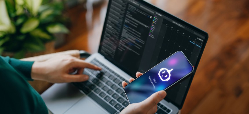 An image of someone using a phone and computer at the same time (d3sign via Getty Images)