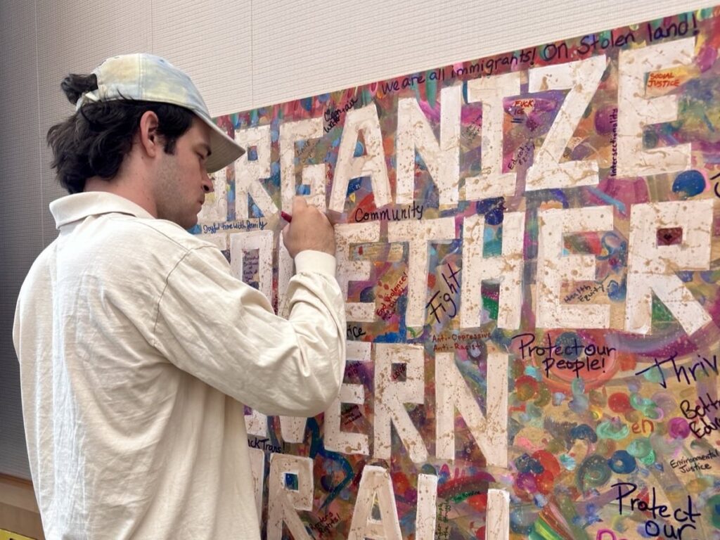 A participants signs the "organize together govern for all" sign