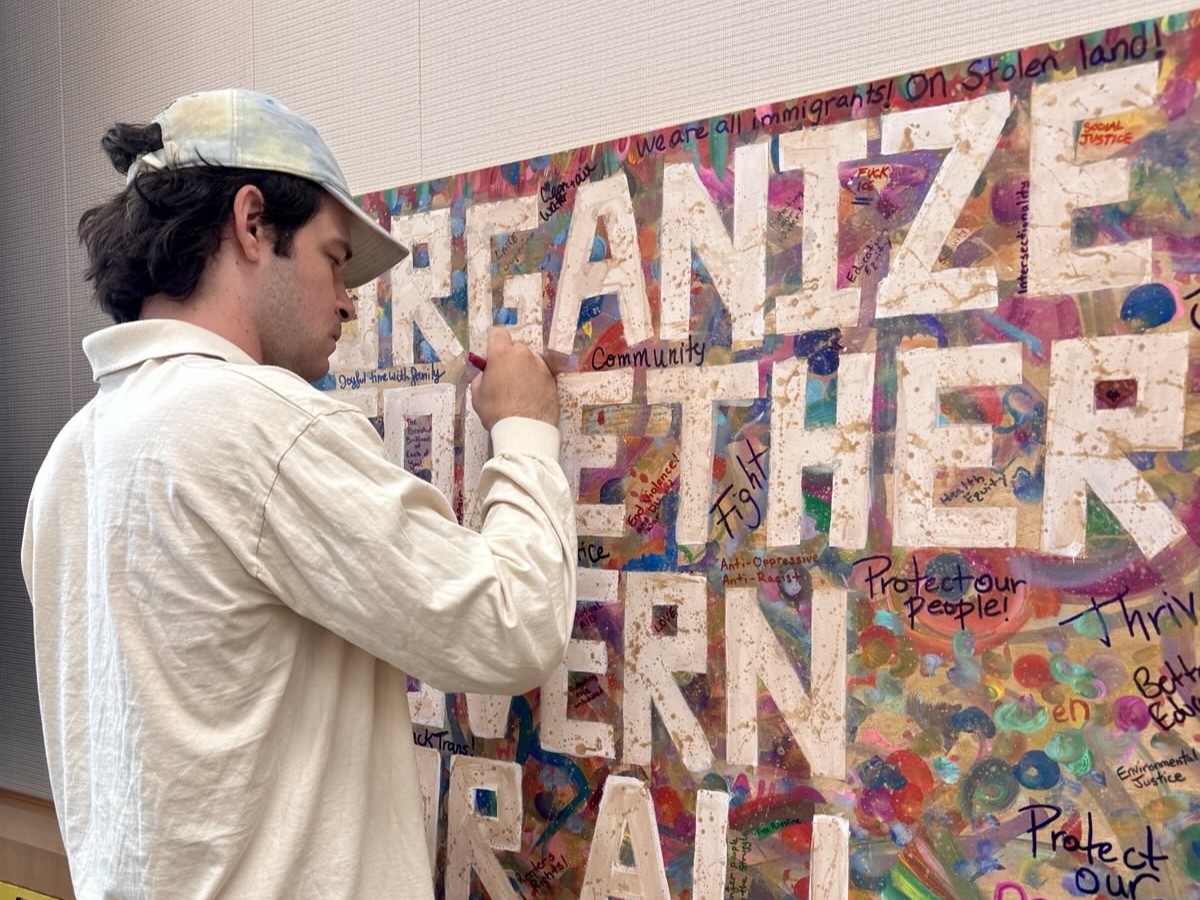 A participants signs the "organize together govern for all" sign
