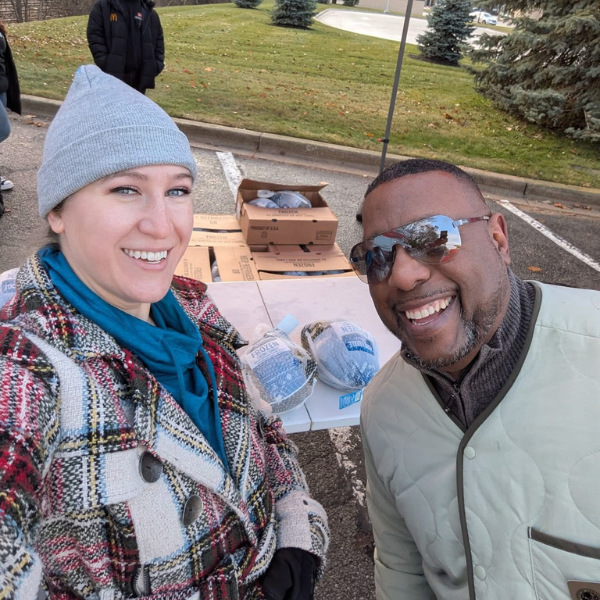 A selfie of two people at a food drive.