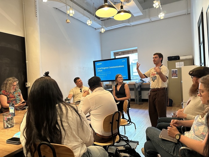 Someone speaking in front of a room full of people